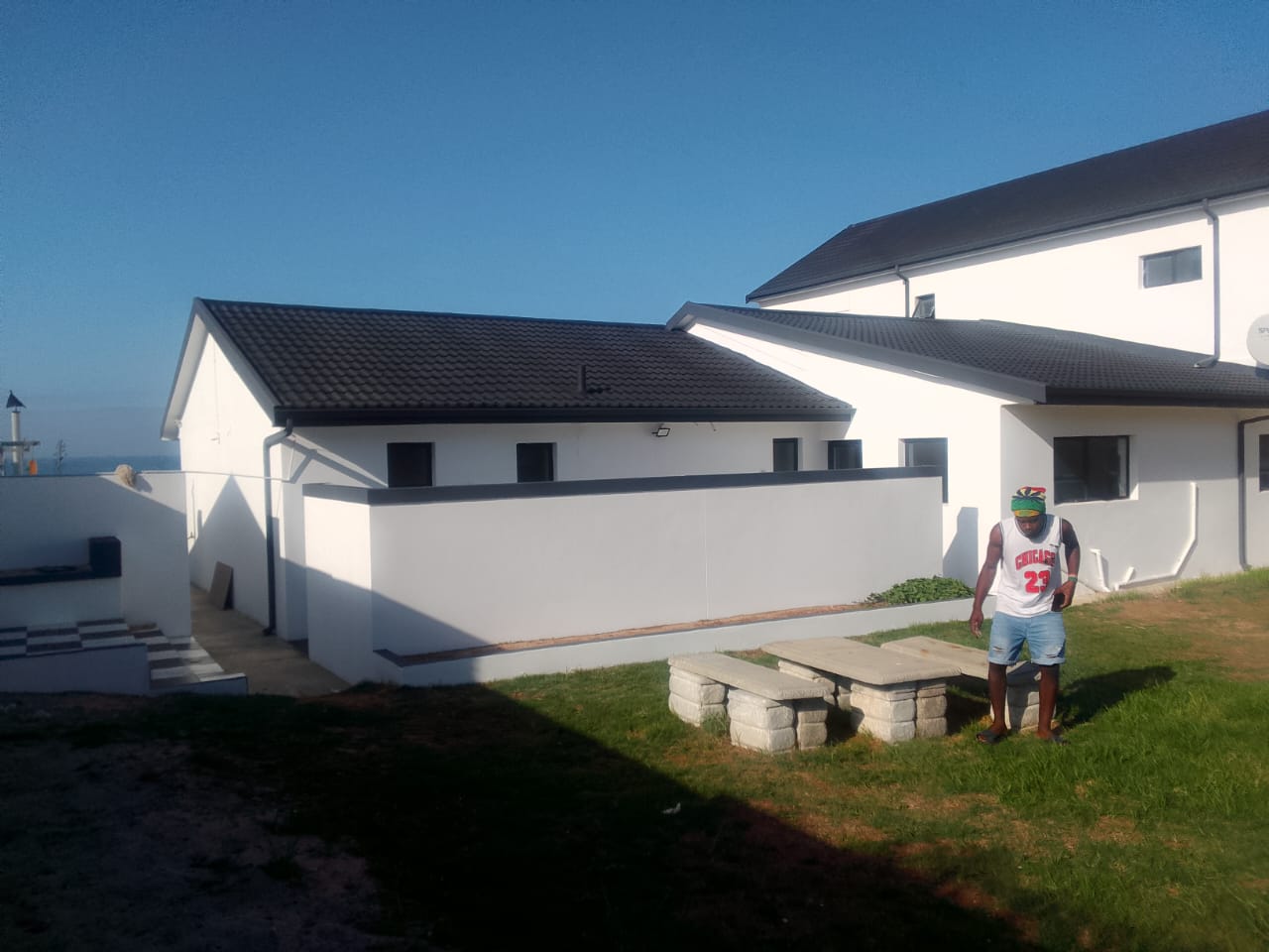 Exterior house painting Gqeberha — finished white-painted home with ocean view, completed by Osflex Construction