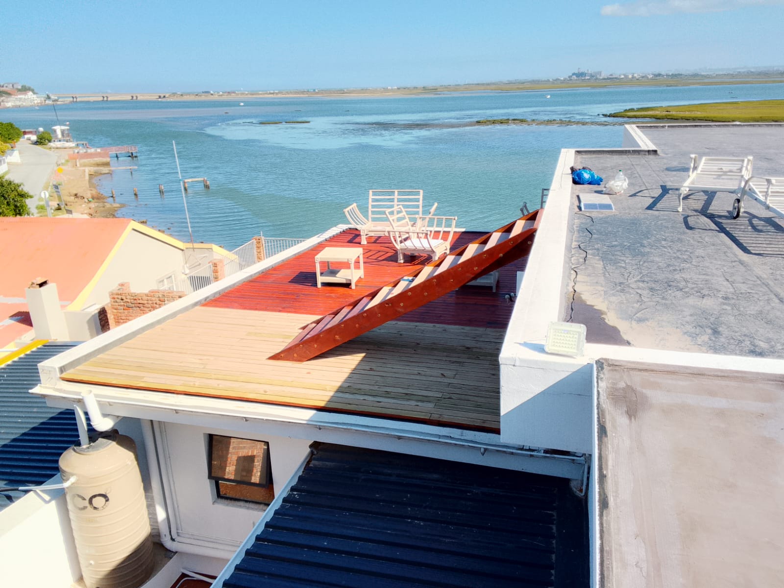 After: Timber deck installers Gqeberha — completed mahogany-stained rooftop deck with lagoon view